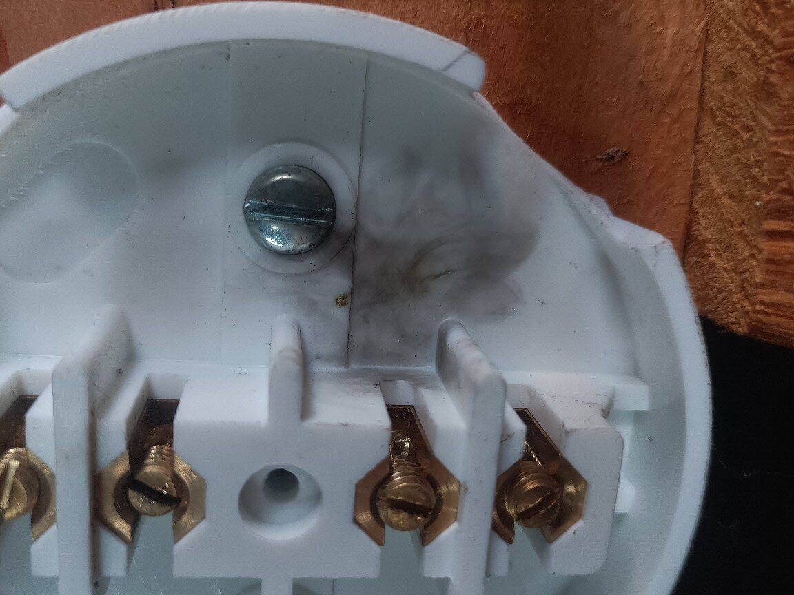 Heat discolouration and thermal damage visible inside a garage socket-circuit junction box