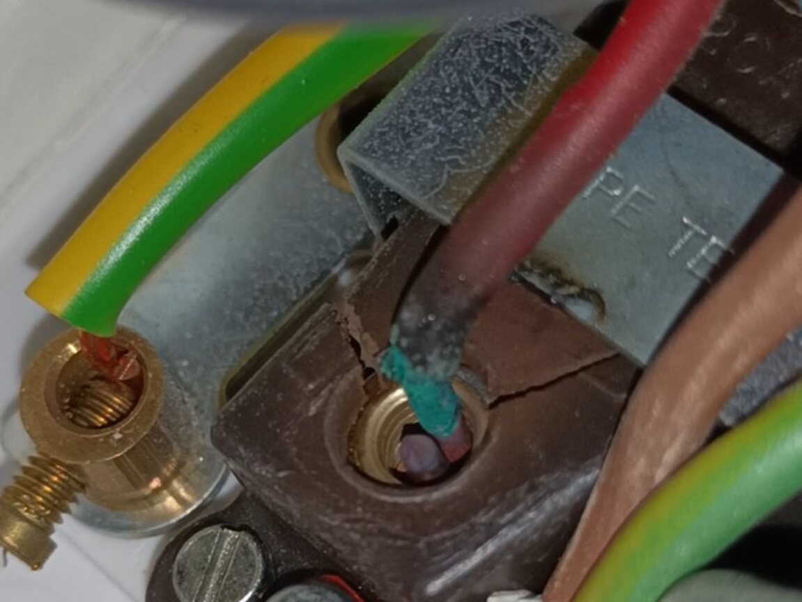 Severe thermal damage around a conductor terminal inside an immersion-heater switched fused connection unit