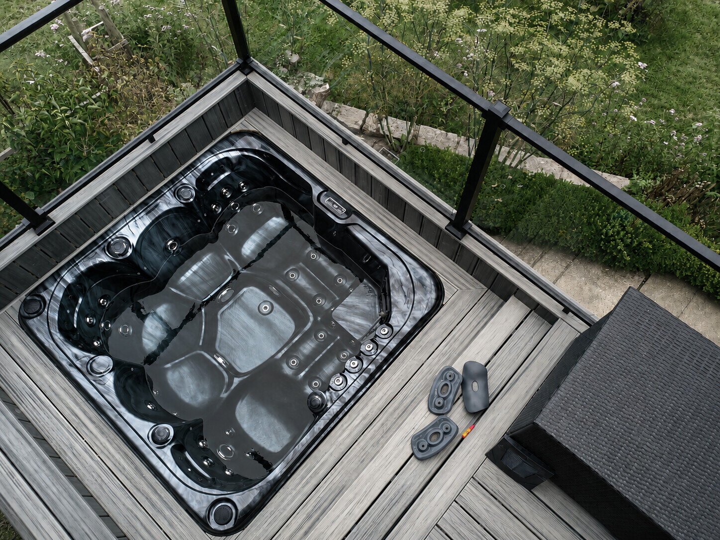 Black hot tub in a garden enclosure during electrical repair work