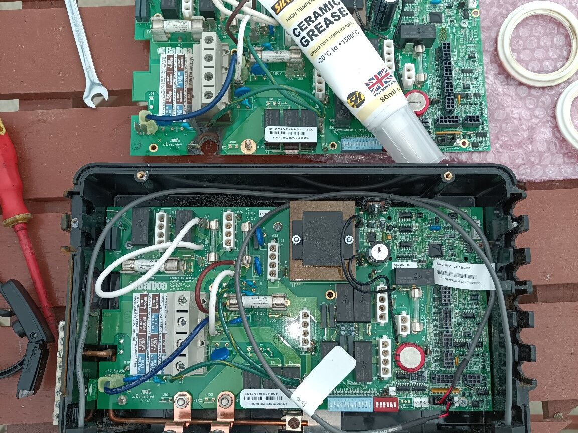 Replacement hot-tub control board positioned inside the control pack with the heater connections visible